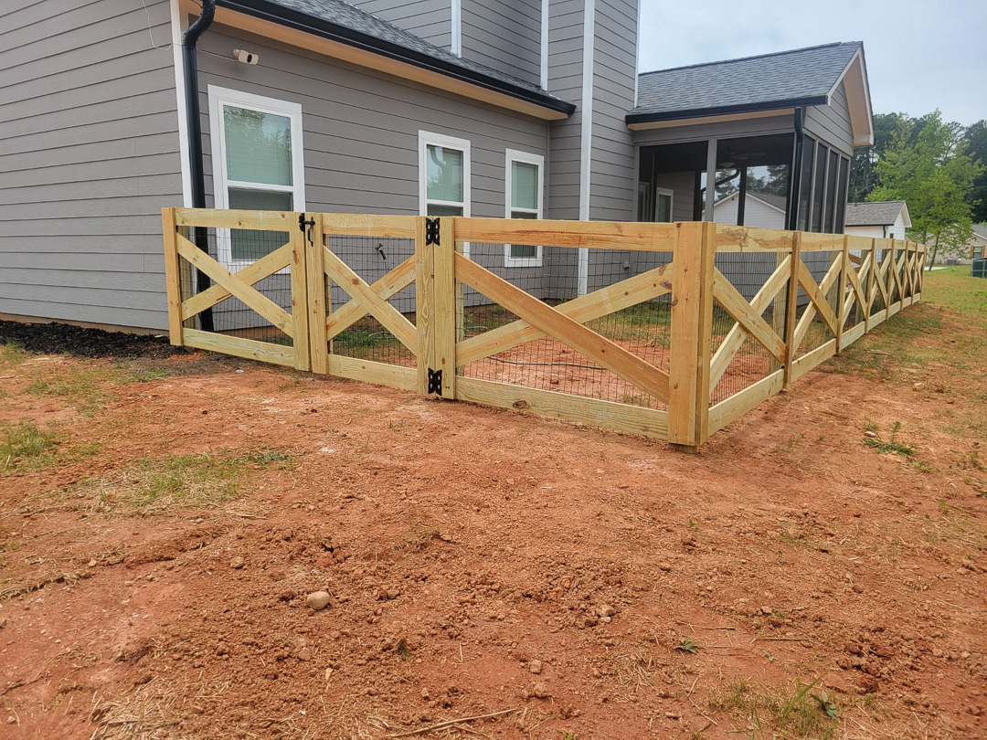 Cross buck wood farm fence beside a new home